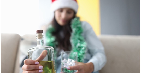 woman with Santa hat holding whiskey